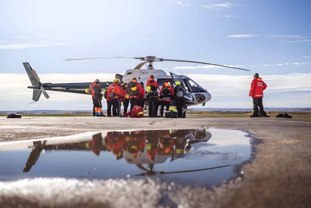 South Peace Search and Rescue members are grouped up on airport tarmac next to a helicopter
